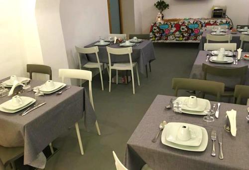een restaurant met tafels en stoelen met borden en keukengerei bij Hotel Diffuso Antichi Ricordi in Caltanissetta