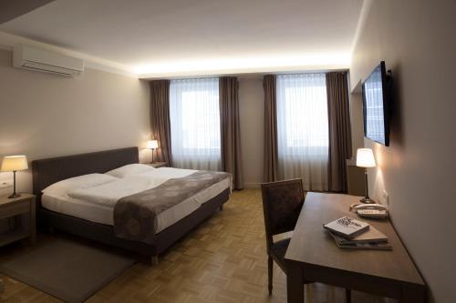 a bedroom with a bed and a desk and a table with a desk at Hotel Slamič Ljubljana in Ljubljana