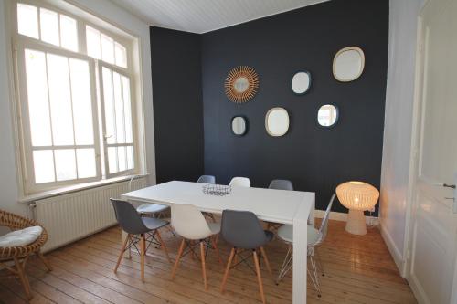 une salle à manger avec une table et des chaises blanches dans l'établissement Villa Touquettoise et Cape Cod, à Le Touquet-Paris-Plage