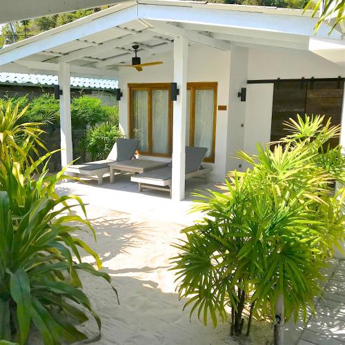 a patio of a house with two lounge chairs at The Cove in Panwa Beach
