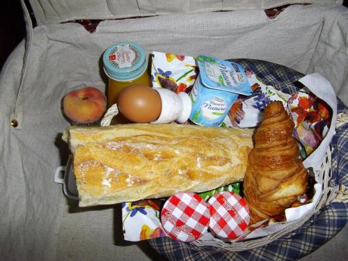 a basket of food with a breakfast of bread and eggs at Maison du Moulin Galuzot in Saint-Vallier