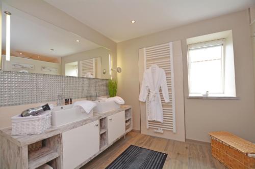 a bathroom with two sinks and a large mirror at Hotel Strand No.1 in Sankt Peter-Ording