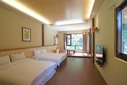 ein Hotelzimmer mit 2 Betten und einem Fenster in der Unterkunft Heaven Bird B&B in Nanzhuang