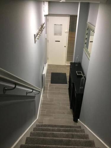 a stairway leading up to a white door with a stair sidx sidx at The Town House Kinsale, Hosted by Exquisite holiday homes, sleeps 16 in Kinsale