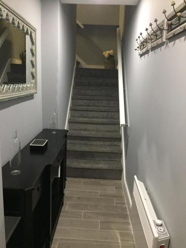 a hallway with a staircase with a mirror and a stair case at The Town House Kinsale, Hosted by Exquisite holiday homes, sleeps 16 in Kinsale