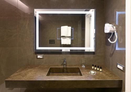 a bathroom with a sink and a mirror at Caruso Place Boutique & Wellness Suites in Naples