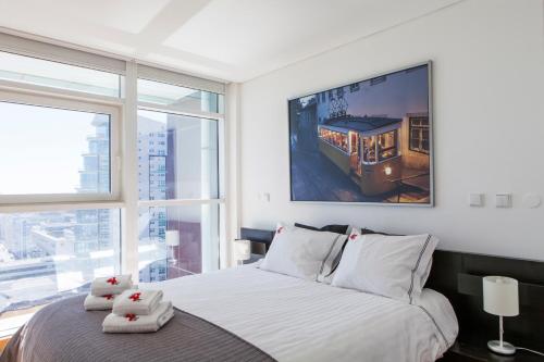 a bedroom with a bed with a picture of a train at RENT4REST LISBON PARQUE DAS NAÇÕES 17Th FLOOR RIVER VIEW in Lisbon