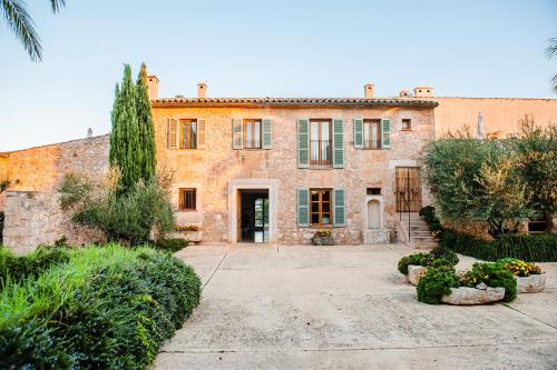 een oud stenen huis met een binnenplaats en bomen bij Hotel Sa Franquesa Nova in Vilafranca de Bonany