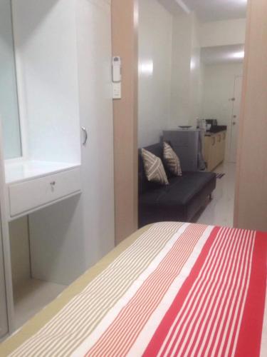 a bedroom with a bed and a couch in a room at The Perfect Getaway in Tagaytay