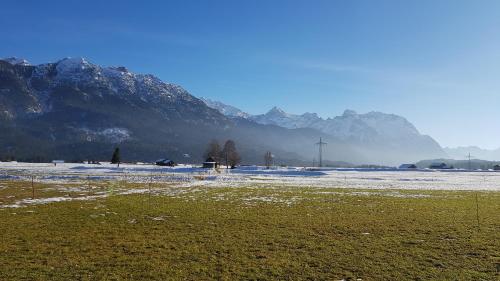 a snow covered field with a mountain in the background at Ferienwohnung Marktstüberl in Mittenwald