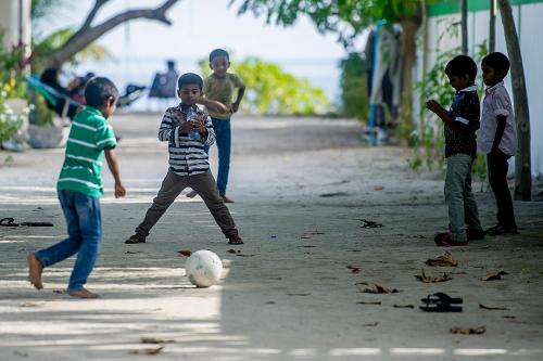 a group of children playing with a soccer ball at Detour Beach View in Hangnaameedhoo
