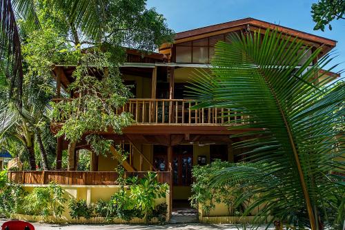 a large house with a balcony and a palm tree at Detour Beach View in Hangnaameedhoo