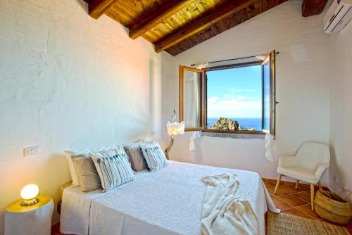 una camera con letto e vista sull'oceano di Villa Brezza Marina a Nebida