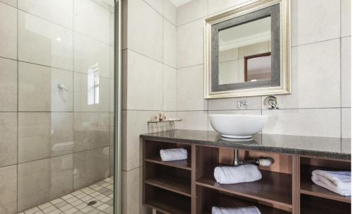 a bathroom with a sink and a shower at Usambara Lodge in Muldersdrift