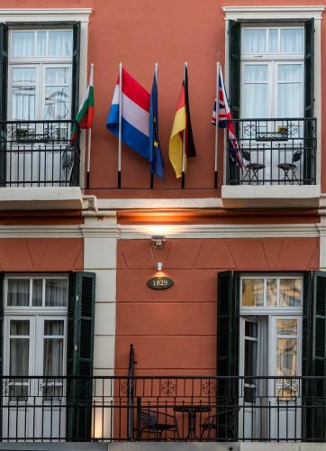 a row of flags on the side of a building at Old Town Inn in Kavala