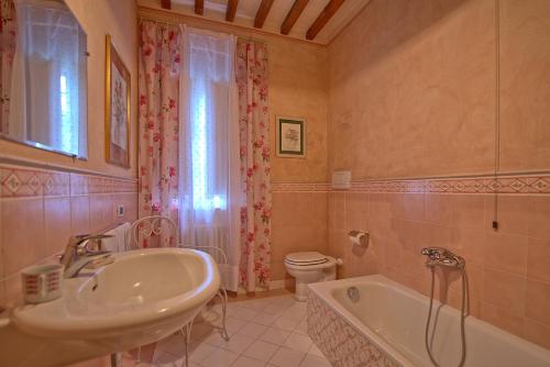 y baño con lavabo, bañera y aseo. en Villa Fontine by PosarelliVillas, en Orentano
