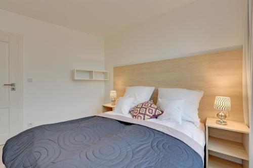 a bedroom with a large bed with two pillows at Chrobry Apartamenty Gdańsk Grodzka 10 in Gdańsk