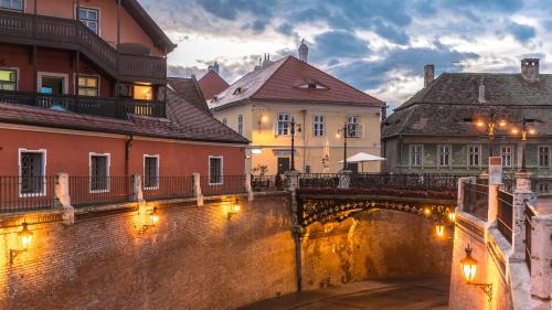 a bridge over a river in a city with buildings at Vila Șaguna in Sibiu