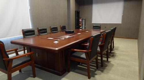 a conference room with a long wooden table and chairs at Hotel Halwachy in As Sulaymānīyah