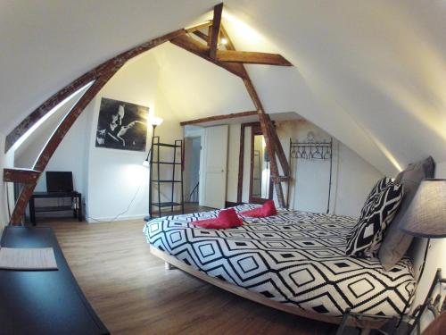 1 dormitorio con 1 cama grande en el ático en Alex Guest House, en Dozulé