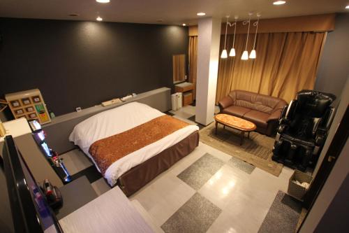 東根市にあるホテル シンドバット 山形店（大人専用）のベッドルーム1室(ベッド1台、椅子、ソファ付)