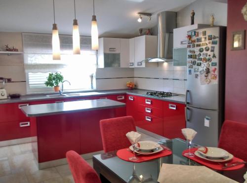 a kitchen with red cabinets and a stainless steel refrigerator at Apartments Europa in Starigrad