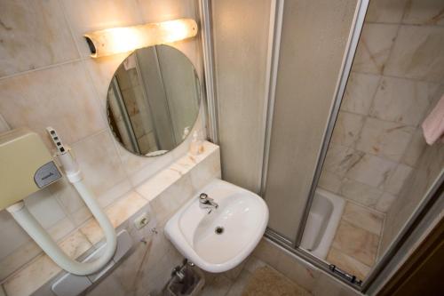 a bathroom with a shower and a sink and a mirror at Villa am Park in Bad Tölz