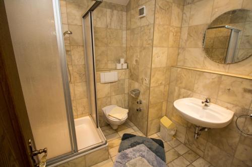 a bathroom with a shower and a sink and a toilet at Villa am Park in Bad Tölz