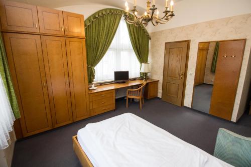 a bedroom with a bed and a desk and a window at Villa am Park in Bad Tölz