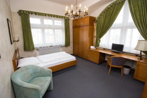 a bedroom with a bed and a desk and a chair at Villa am Park in Bad Tölz