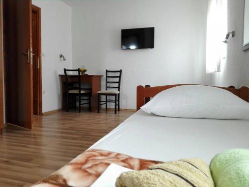 a bedroom with a bed and a table with chairs at Pansion Crnjac in Međugorje