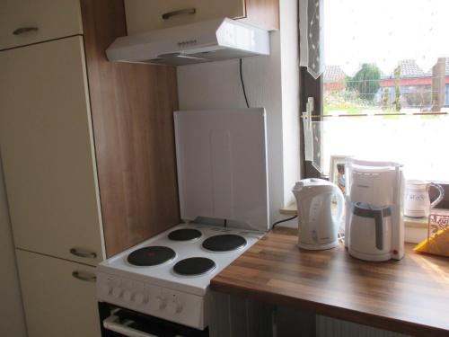 a small kitchen with a stove and a refrigerator at Apartments in Behringersmühle in Gößweinstein