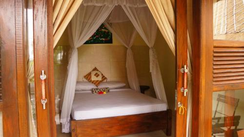 ein kleines Bett in einem Zimmer mit Fenster in der Unterkunft Rumahku Homestay in Amed