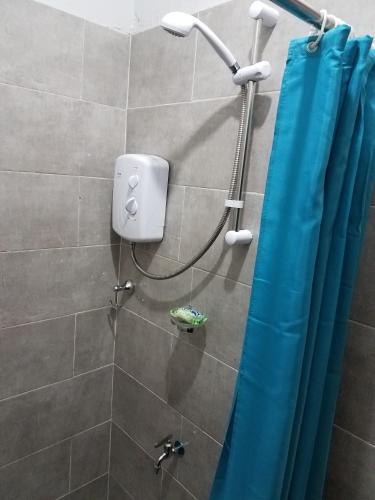 a shower with a blue shower curtain in a bathroom at Sharp Guesthouse in Accra
