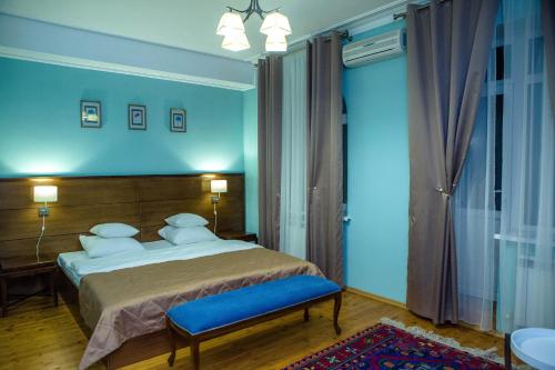 a bedroom with a bed and a blue wall at Hotel Metropol in Derbent
