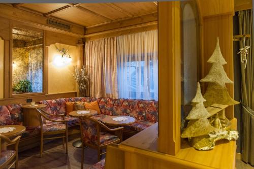 a living room with a couch and a christmas tree at Hotel Italia in Castello di Fiemme