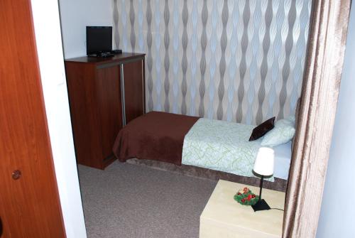 a small bedroom with a bed and a mirror at Villa Green in Oświęcim