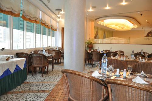 a dining room with tables and chairs in a restaurant at Grand Continental Hotel in Abu Dhabi