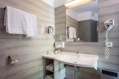 a bathroom with a sink and a mirror at Hotel Le Chatard in Sarcey