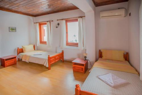 a bedroom with two beds and two windows at Shtastlivcite Family Hotel in Starozagorski Bani