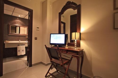 een computer op een bureau in een badkamer met een spiegel bij Casa Baños de la Villa in Priego de Córdoba