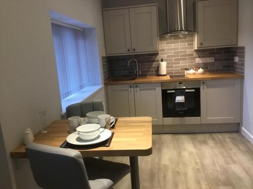 a kitchen with a wooden table and a dining room at Bickfield Annexe in Ubley