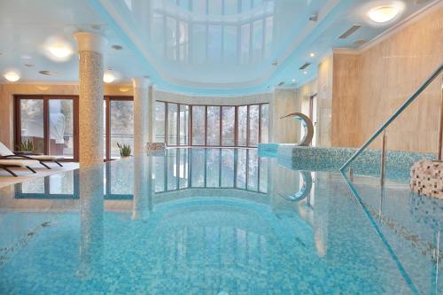 a pool in a hotel with a large swimming pool at Retro Riverside Wellness Resort in Karlovy Vary