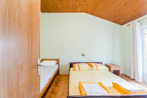 a bedroom with a bed with a wooden ceiling at Apartments Ivica - with parking in Nin
