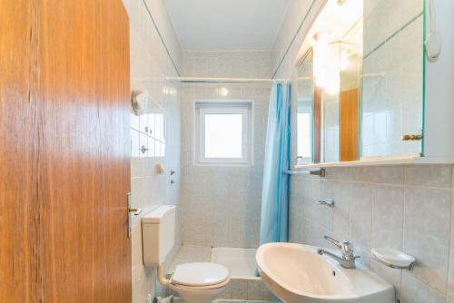 a bathroom with a sink and a toilet and a mirror at Apartments Ivica - with parking in Nin