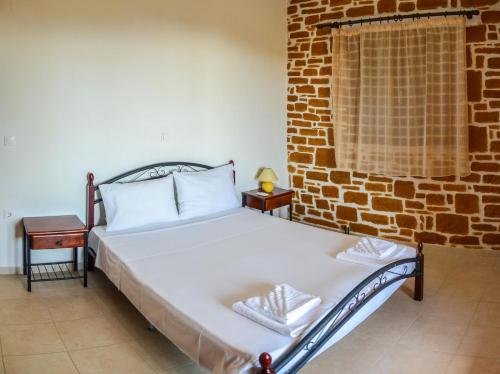 uma cama num quarto com uma parede de tijolos em PETRA-MARE 6 em Triopetra