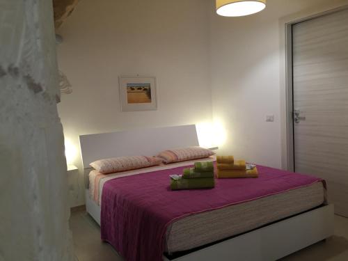 a bedroom with a bed with a purple blanket at B&B Casa Lucrezia in Scicli
