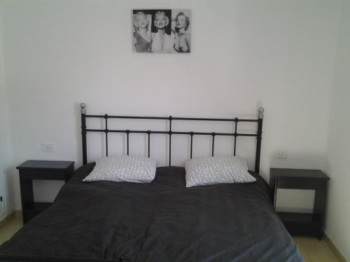プラヤ・デ・ラス・アメリカスにあるParaiso Royal Dany & Pinaのベッドルーム1室(黒いベッド1台、ナイトスタンド2台付)