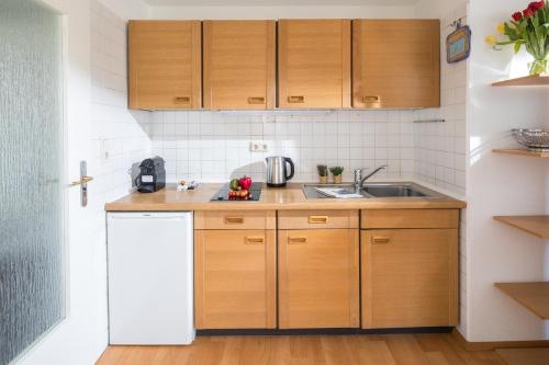 a kitchen with wooden cabinets and a sink at Birkenhof in Norderney