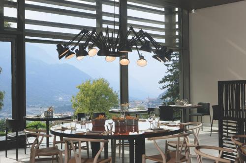 a dining room with tables and chairs and a chandelier at Parc Hotel Billia in Saint Vincent